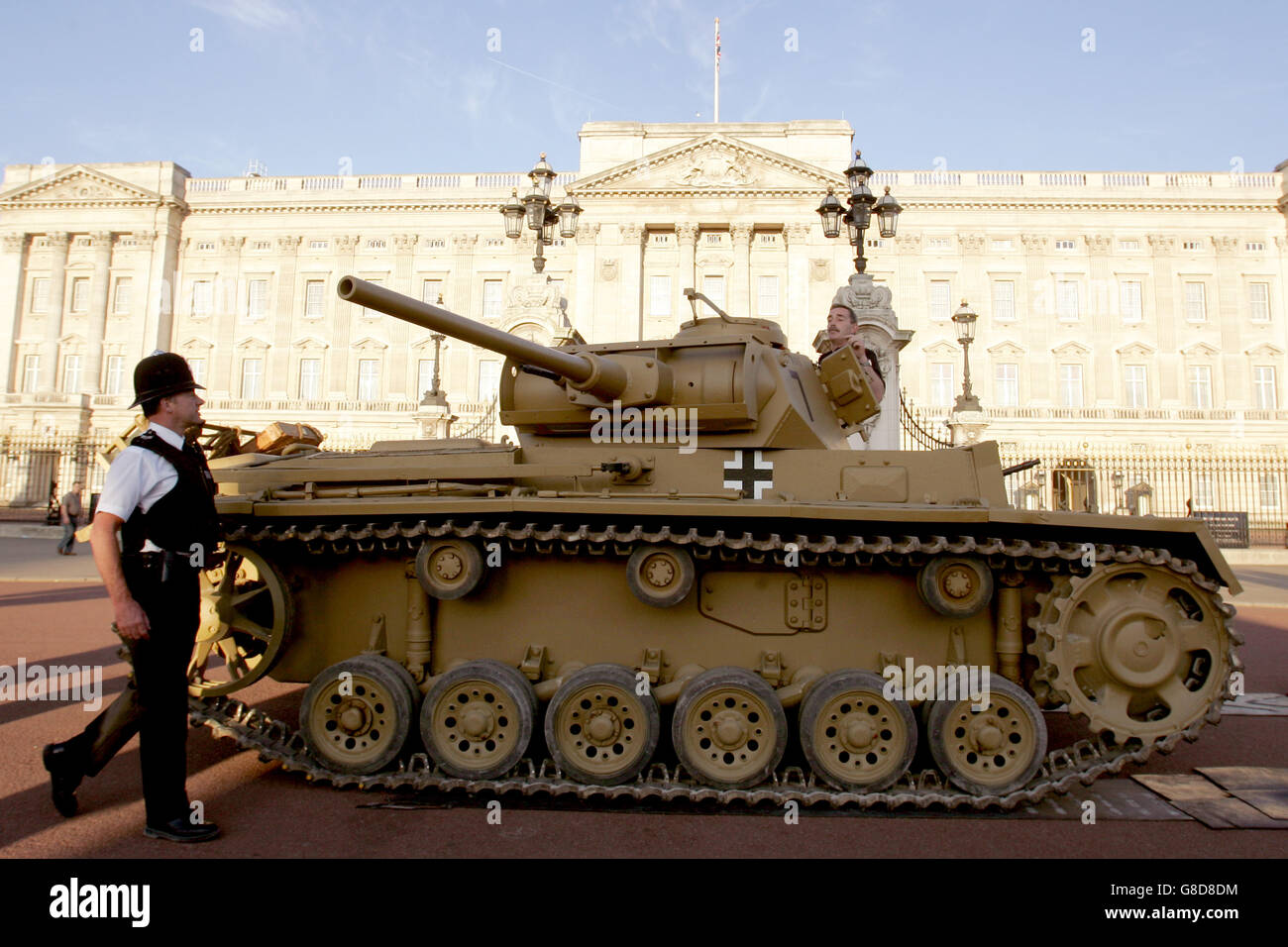 A police officer takes a look at a German Panzer III tank parked outside Buckingham Palace in London. The tank was on its way to St James's Park where it will be on display as part of the Living Museum - an exhibition which is part of the commemoration of the 60th anniversary of the end of the Second World War. Stock Photo