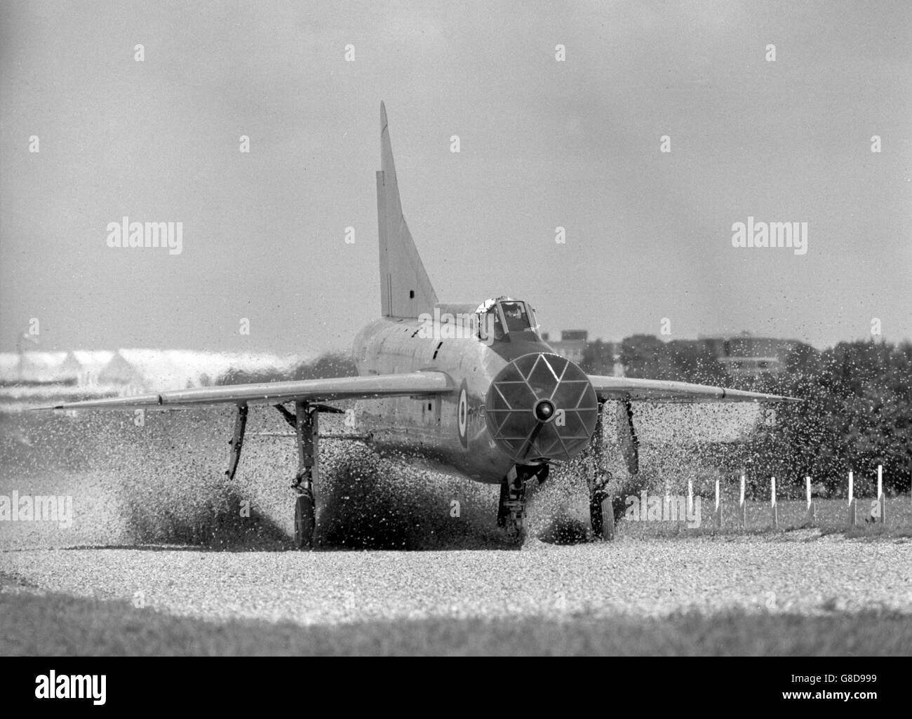 Shingle scatters as a Lightning (the first British plane to fly at Mach 2 in November 1958) plunges into the loose material to land during arrester trials at Farnborough, Hampshire. The trials were a continuation of experiments to find a material that will safely decelerate a civil aircraft should it make a bad landing and overshoot the runway. Stock Photo