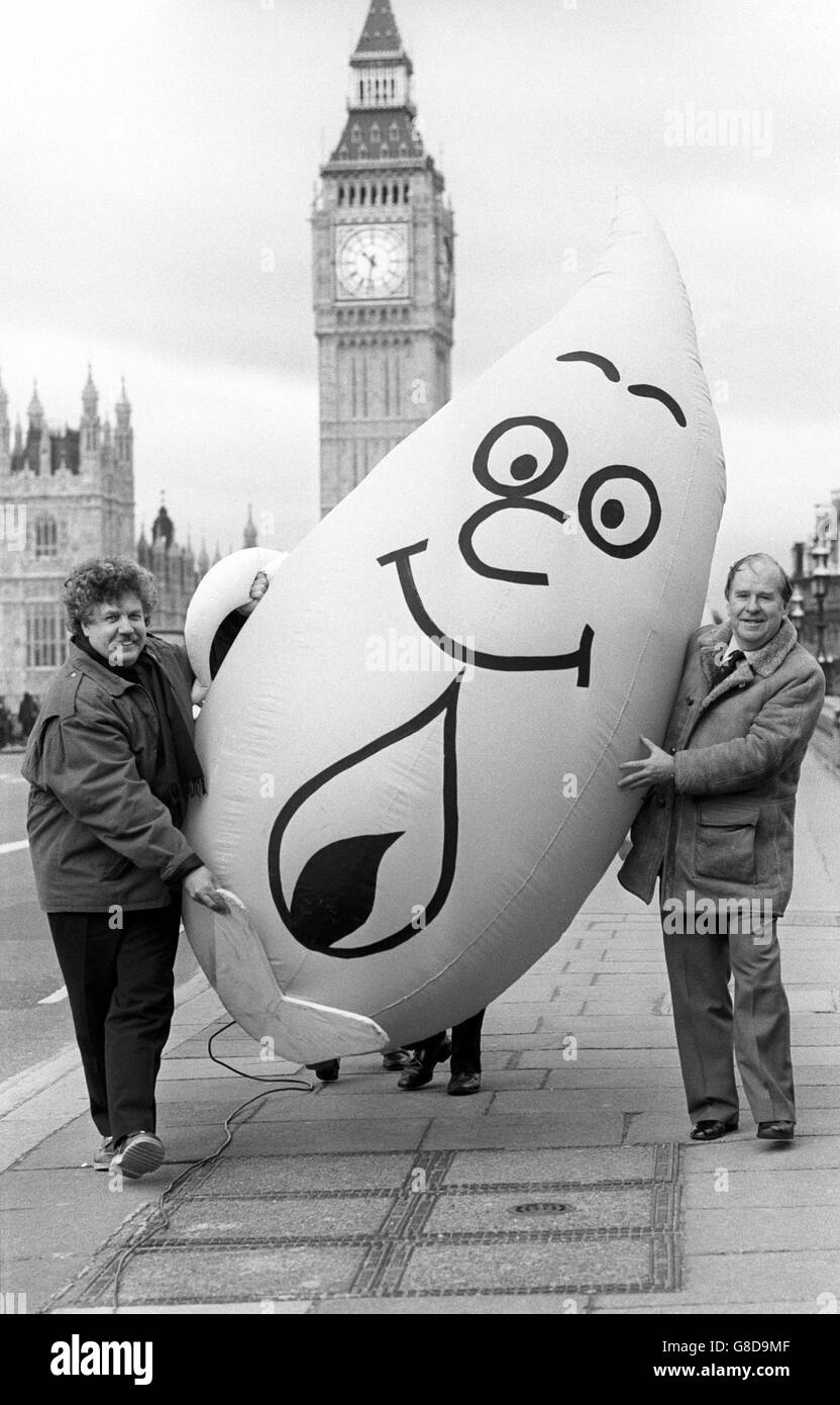 Actor Colin Welland (l) helping to launch the Labour Party's 'Keep Gas Public' campaign by giving Shadow Secretary of State for Energy Stan Orme a helping hand walking the 10ft tall inflatable campaign mascot, 'Mr Therm', across Westminster Bridge in London. Stock Photo