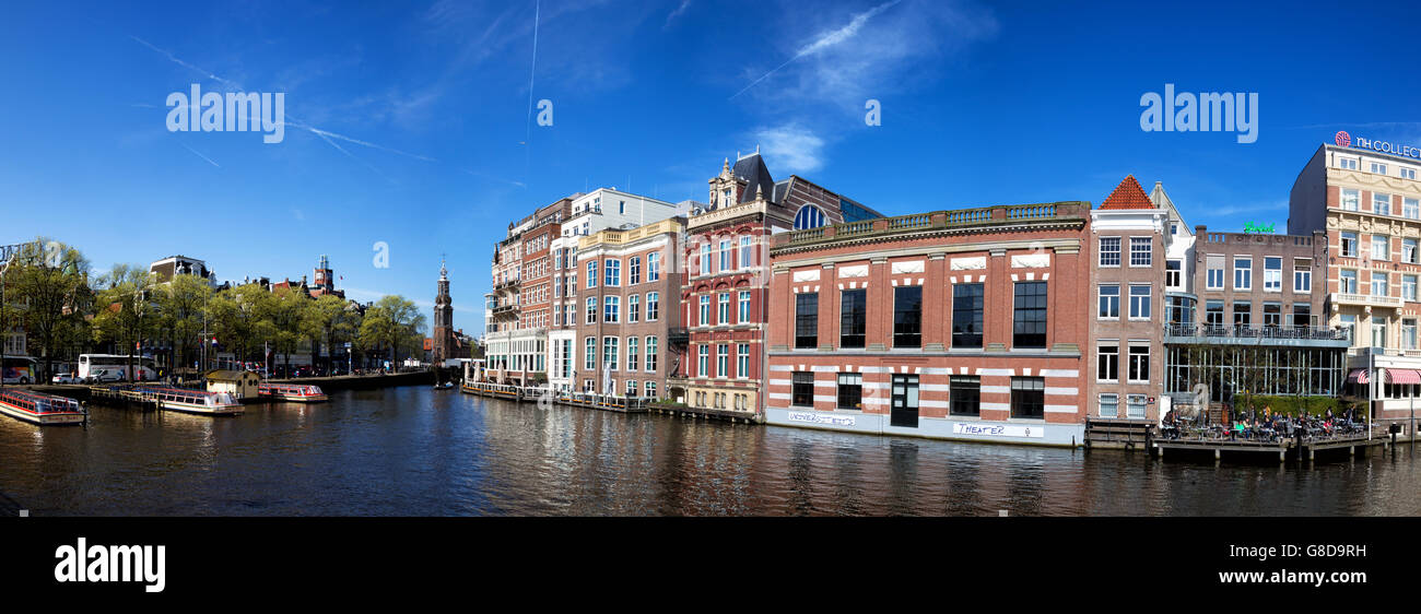 Panorama of the Amstel river with view on the Munttoren or Mint Tower in downtown Amsterdam, Netherlands in spring. Stock Photo