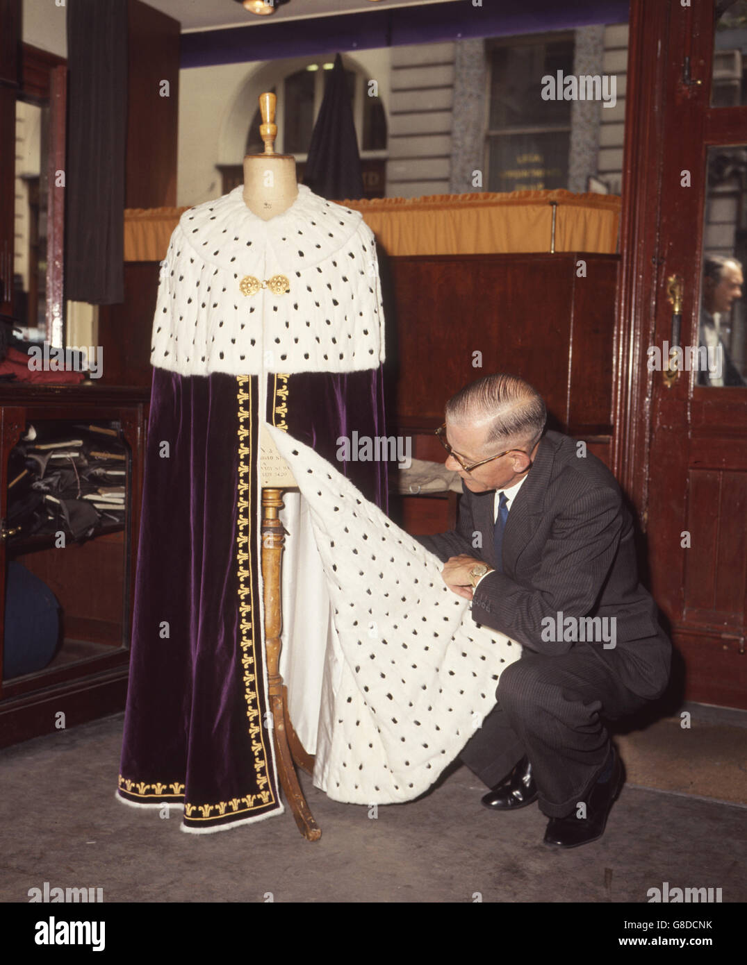 The Mantle for Prince Charles' investiture as Prince of Wales, seen at Ede & Ravenscroft London robe makers. It is hand woven in Royal purple silk velvet (from Warners, Braintree, Essex). Prince of Wales feathers are in gold wire. Collar secured by 18t Welsh gold classed at the 1911 investiture. Stock Photo