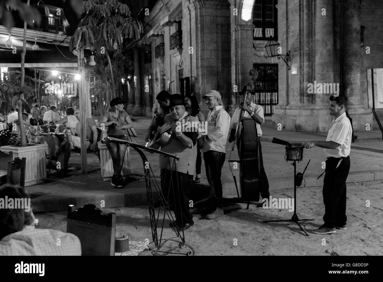 Cuban orchestra plays in front of the restaurant at night in Old Havana, Cuba, near Plaza de Armas square. Black & white image. Stock Photo