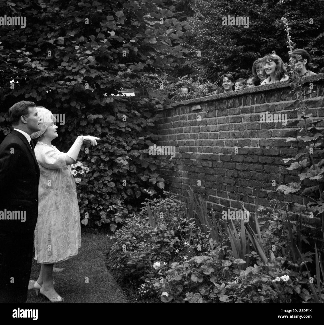 Neighbours of G.W. Lancaster were able to chat from his guest, Queen Elizabeth The Queen Mother, in the garden of his home at Cambridge Gardens in Kensington, London. The Queen Mother was on a tour arranged by the London Gardens Society. Stock Photo