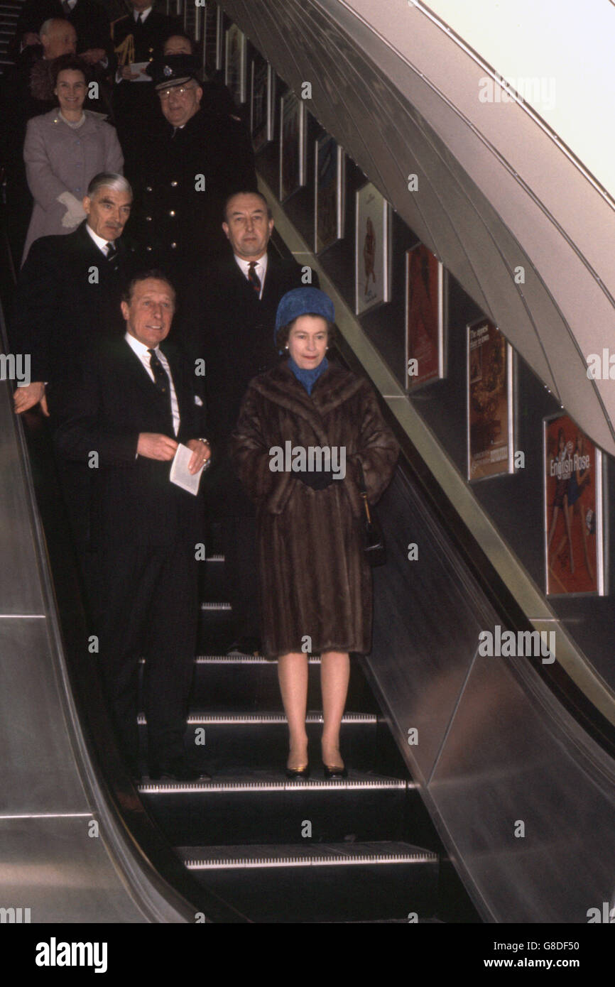 The Queen travelling down the escalator at Green Park Underground station as she opens the new section of the Victoria Line on the London Underground. Stock Photo