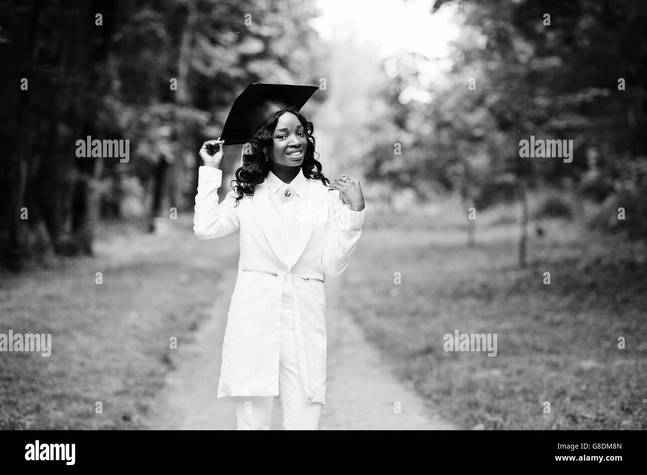 Happy beautiful black african american girl with hat graduates Stock