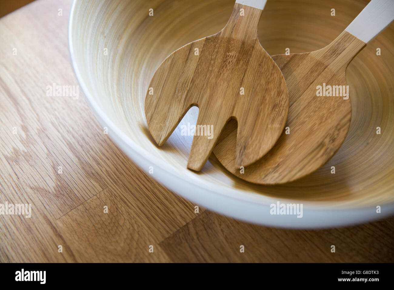 wooden salad servers in white bowl Stock Photo