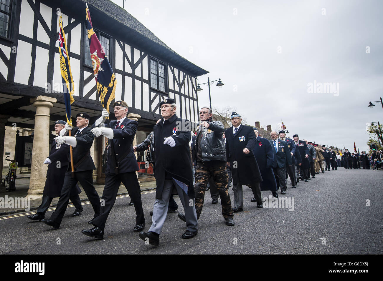 Royal British Legion standard bearers lead a parade along the High