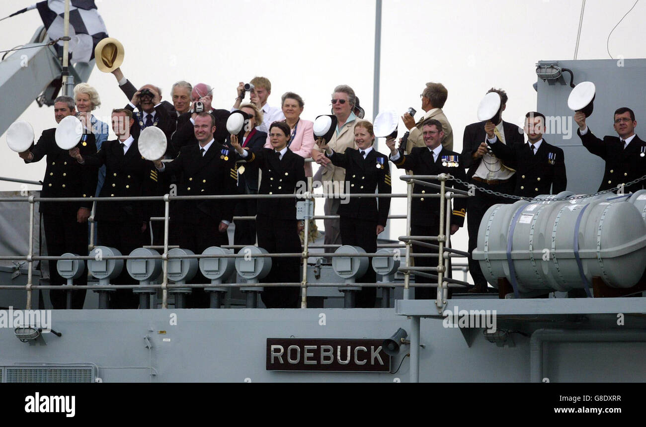 Naval officers salute on board HMS Roebuck, as HMS Endurance passes, carrying Britain's Queen Elizabeth II and the Duke of Edinburgh on board. Stock Photo