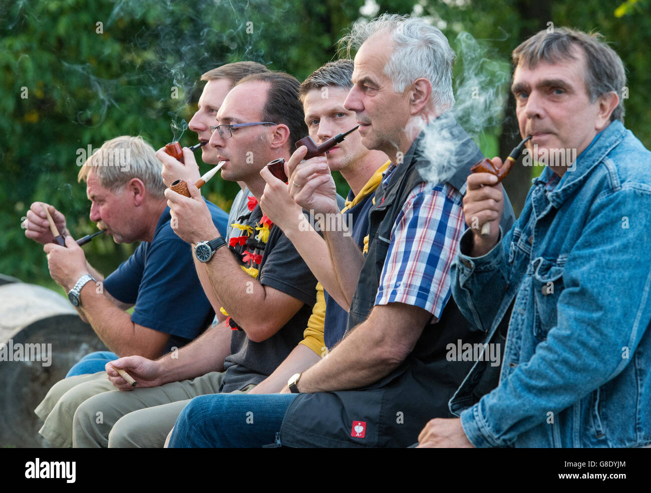 Members of the competing in smoking a pipe as slow as