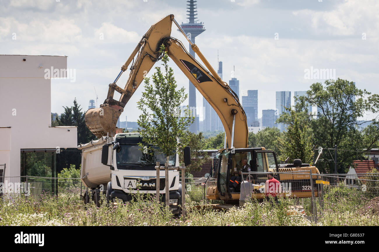 An excavator creates the foundation for an upmarket private residential building with a view of the city skyline in the Riedberg area of Frankfurt am Main, Germany, 29 June 2016. Photo: FRANK RUMPENHORST/dpa Stock Photo