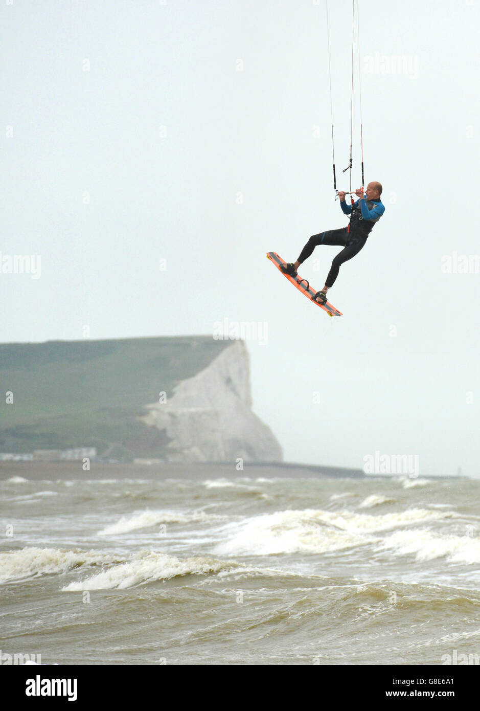 Seaford, UK. 29th June 2016. Kite surfers take advantage of the wet and windy summer weather in Seaford Bay, East Sussex. Credit: Peter Cripps/Alamy Live News Stock Photo