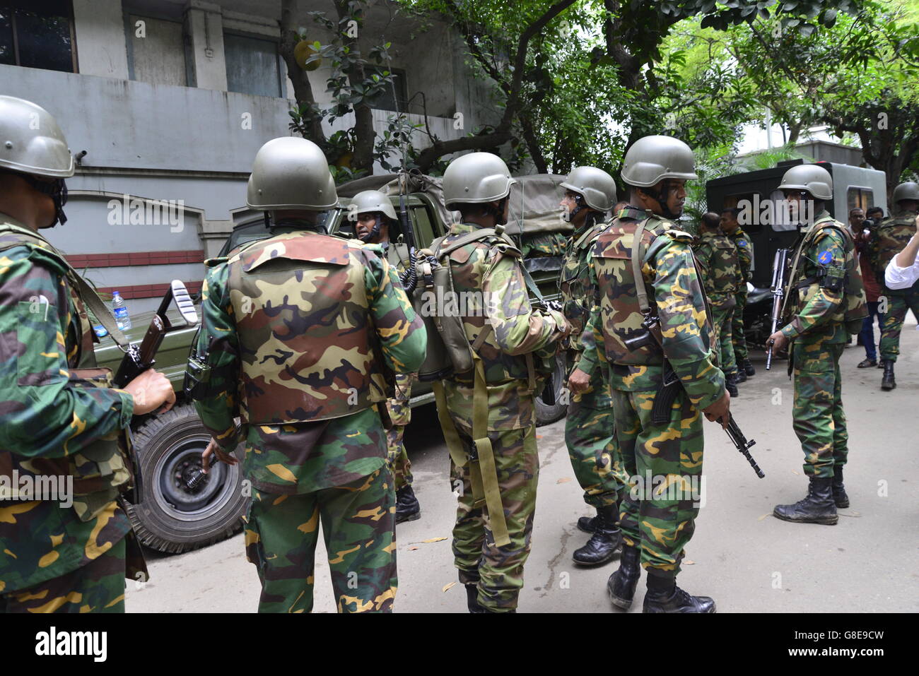 Bangladeshi soldiers and police walk along a street leading to an upscale restaurant in Dhaka on July 2, 2016, following a bloody siege there by armed attackers that began on July 1. Heavily armed militants murdered 20 hostages in Bangladesh, hacking many of their victims to death, before six of the attackers were gunned down at the end of a siege July 2 at a restaurant packed with foreigners. As the Islamic State (IS) group claimed responsibility for the carnage at the start of the Eid holiday, Prime Minister Sheikh Hasina said she was determined to eradicate militancy in the mainly Muslim na Stock Photo