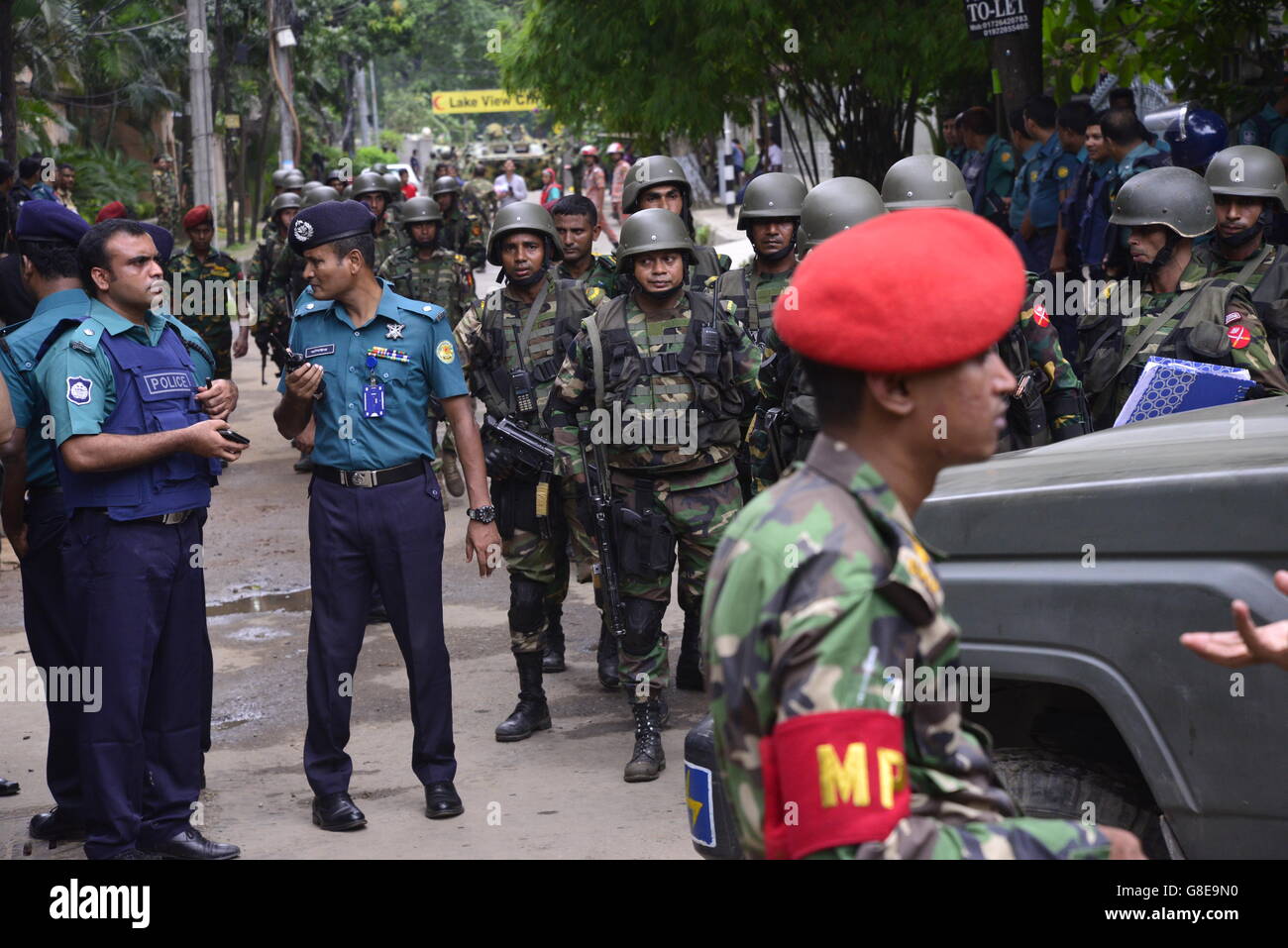 Bangladeshi soldiers and police walk along a street leading to an ...