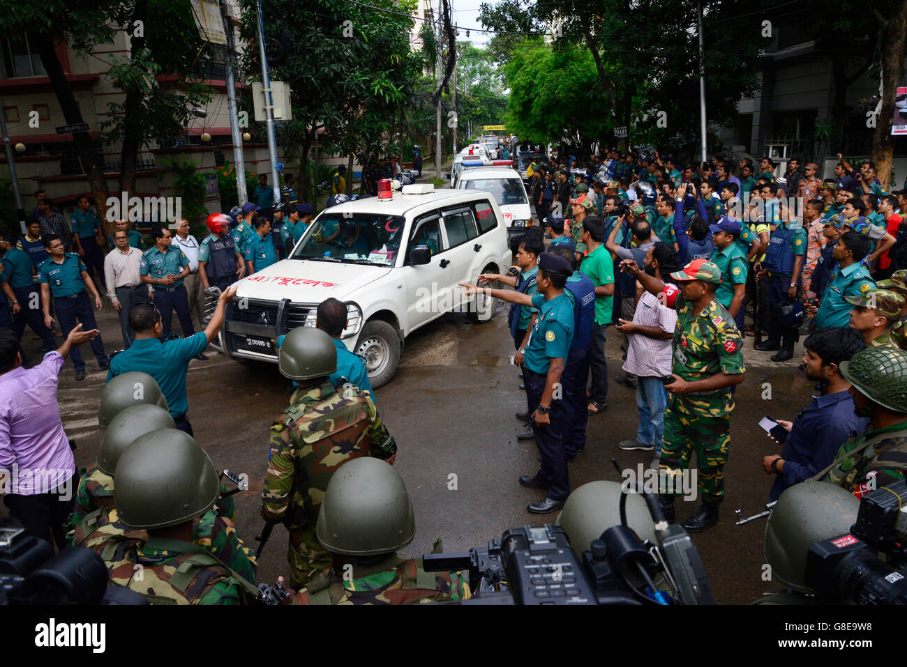 Ambulances believed to be carrying the bodies of some of the hostages that were killed in a bloody attack on an upscale restaurant in the Bangladeshi capital Dhaka leave the vicinity of the attack site on July 2, 2016. Heavily armed militants murdered 20 hostages in Bangladesh, hacking many of their victims to death, before six of the attackers were gunned down at the end of a siege July 2 at a restaurant packed with foreigners. As the Islamic State (IS) group claimed responsibility for the carnage at the start of the Eid holiday, Prime Minister Sheikh Hasina said she was determined to eradica Stock Photo