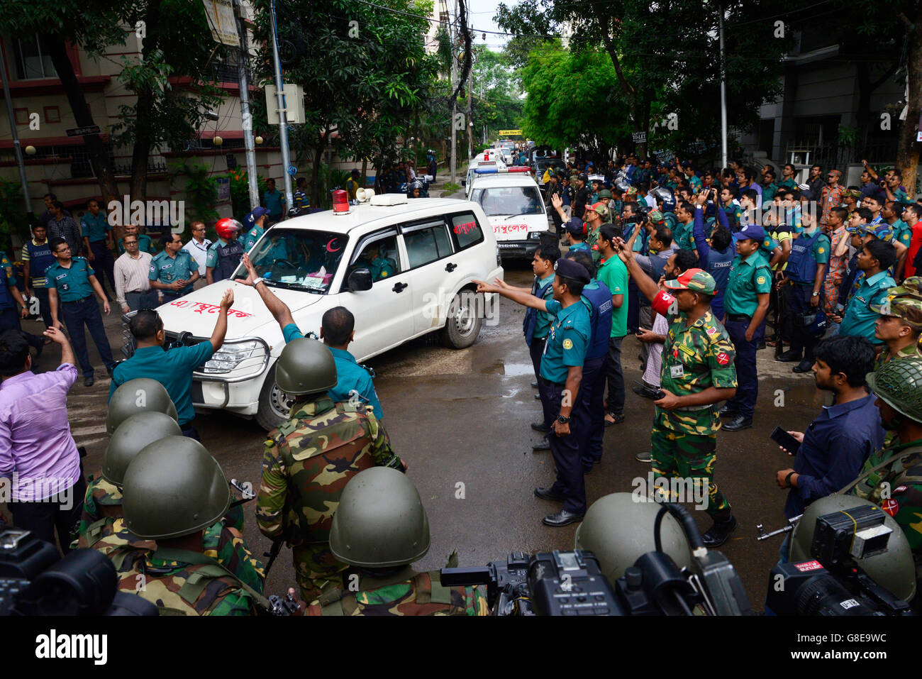 Ambulances believed to be carrying the bodies of some of the hostages that were killed in a bloody attack on an upscale restaurant in the Bangladeshi capital Dhaka leave the vicinity of the attack site on July 2, 2016. Heavily armed militants murdered 20 hostages in Bangladesh, hacking many of their victims to death, before six of the attackers were gunned down at the end of a siege July 2 at a restaurant packed with foreigners. As the Islamic State (IS) group claimed responsibility for the carnage at the start of the Eid holiday, Prime Minister Sheikh Hasina said she was determined to eradica Stock Photo