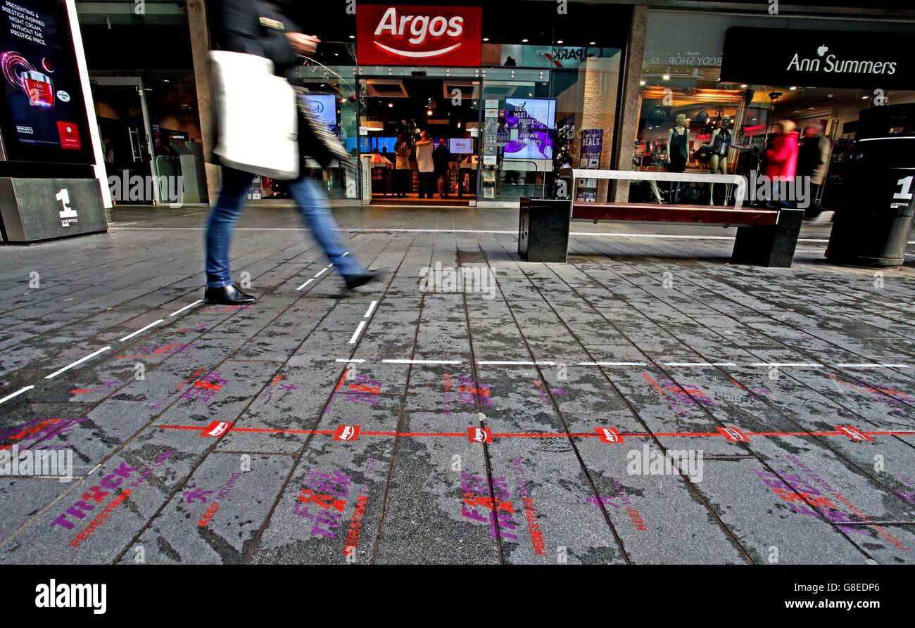 Shoppers in the Liverpool One shopping complex walk past and along the