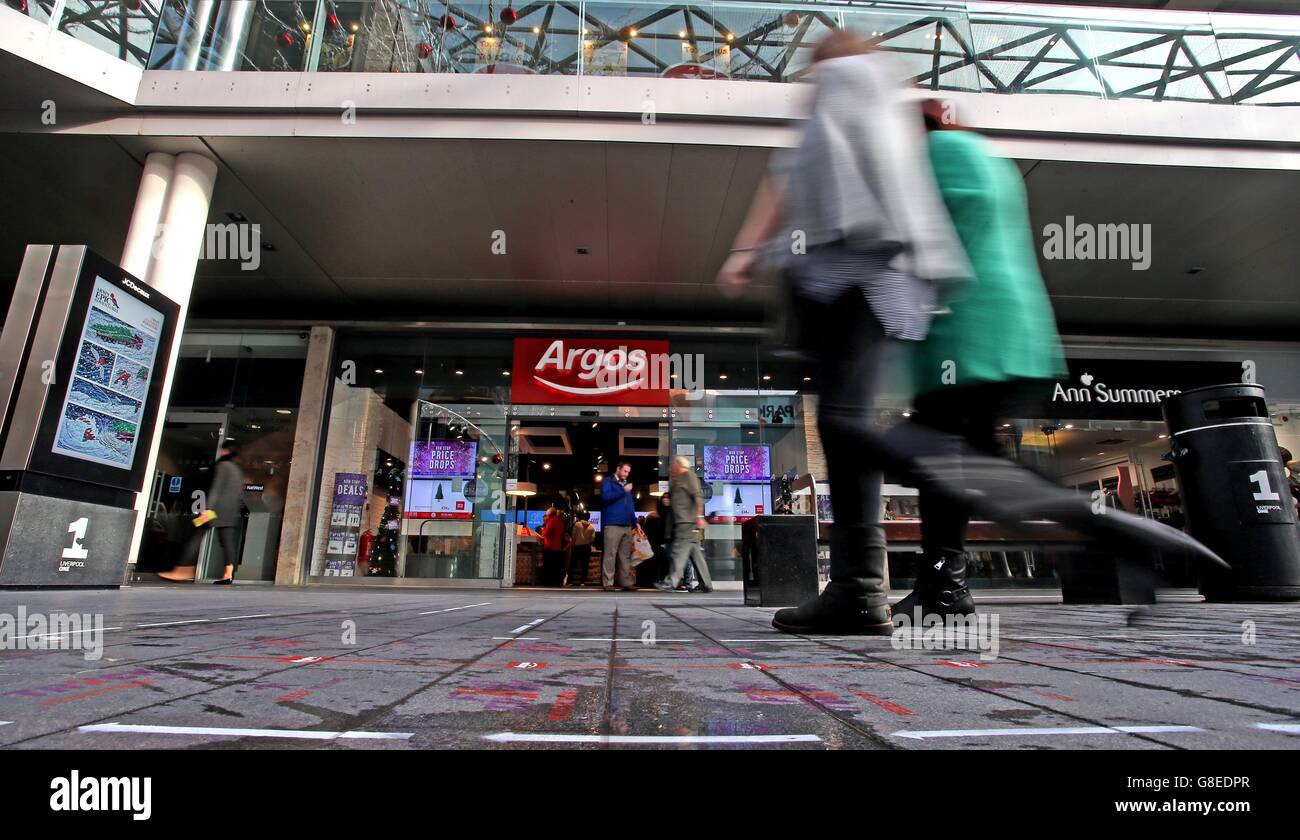 Shoppers in the Liverpool One shopping complex walk past and along the pedestrian fast track lane that retailer Argos has installed, which is aimed at cutting queuing times. Stock Photo
