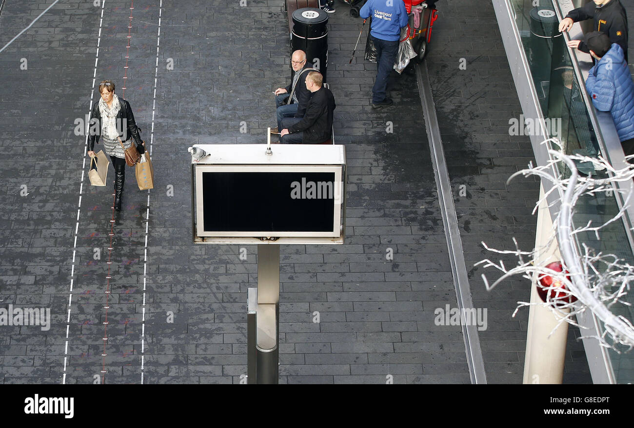 Shoppers in the Liverpool One shopping complex walk past and along the