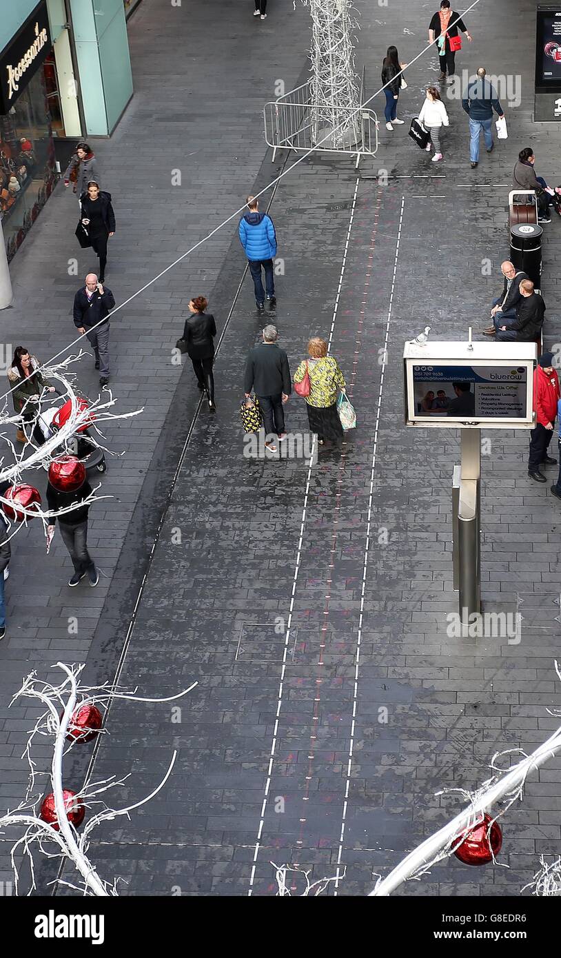 Shoppers in the Liverpool One shopping complex walk past and along the