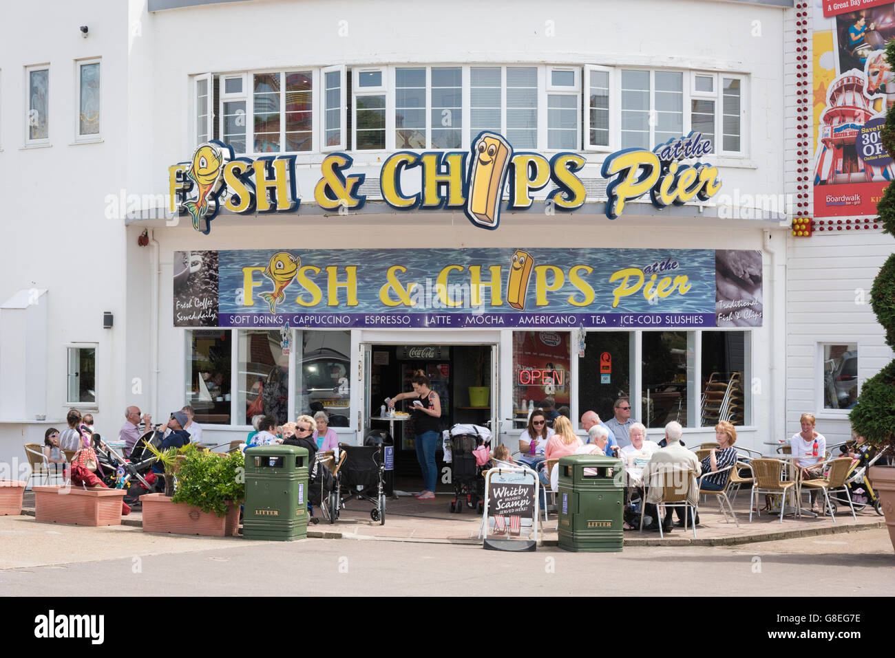 A fish and chip shop at Clacton Pier UK with people eating outside at tables Stock Photo