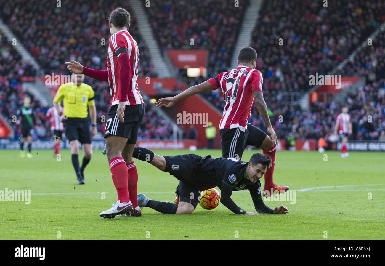 Stoke City's Bojan Krkic goes to ground in the penalty area after a challenge from Southampton's Virgil Van Dijk and Ryan Bertrand during the Barclays Premier League match at St Mary's Stadium, Southampton. Stock Photo