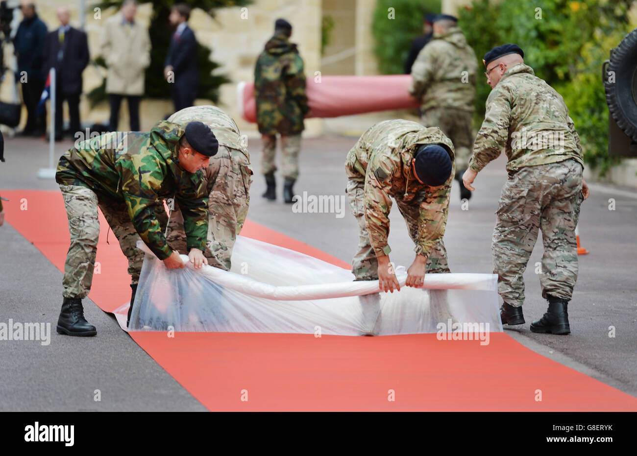 A group of Maltese Soldiers unwrap the red carpet in preparation for the arrival of Queen Elizabeth II and the Duke of Edinburgh at the San Anton Palace for her visit to the island of Malta. Stock Photo