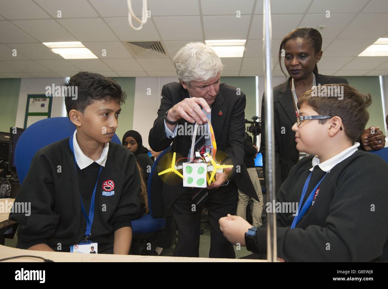 Students Hamza (left) and Andrei (right), show BBC director-general Tony Hall and their principal Chinye Jibunoh their blimp creation using a micro:bit during a visit to Eastlea Community School in Newham, east London, where children have been trialling the micro:bit ahead of them being distributed to other children by the BBC next year. Stock Photo