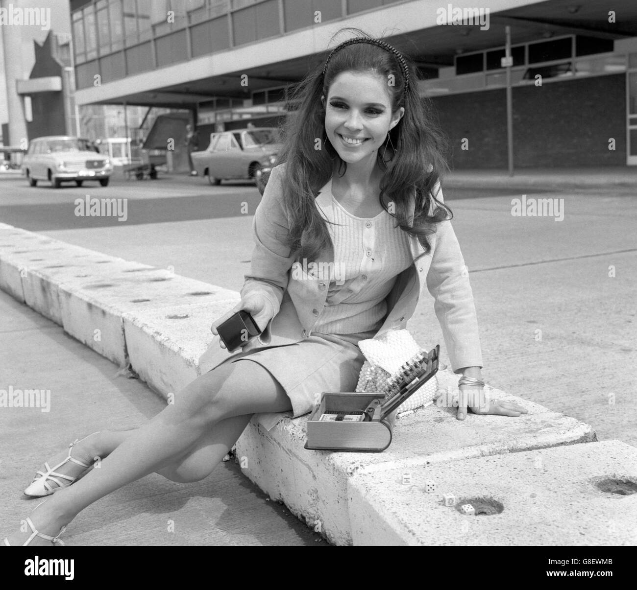 Viviane Ventura, the actress who recently completed a co-starring role with Cliff Richard in the film 'Finders Keepers', passes the time while waiting for her plane at London Airport. Stock Photo