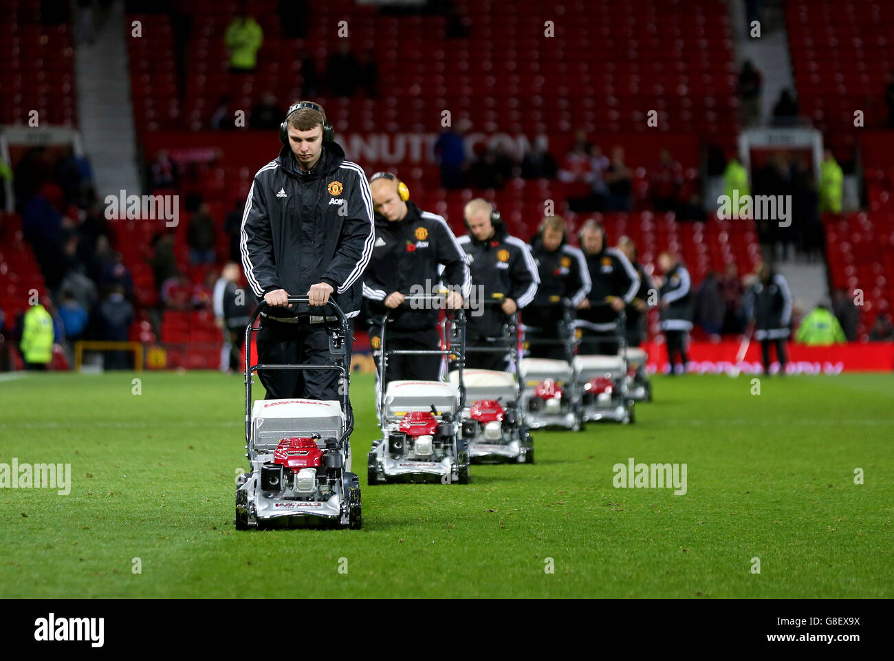 Soccer - Barclays Premier League - Manchester United v West Bromwich Albion - Old Trafford. Groundsmen with lawnmowers cut the grass and clear the sods of turf from the pitch surface after the game. Stock Photo