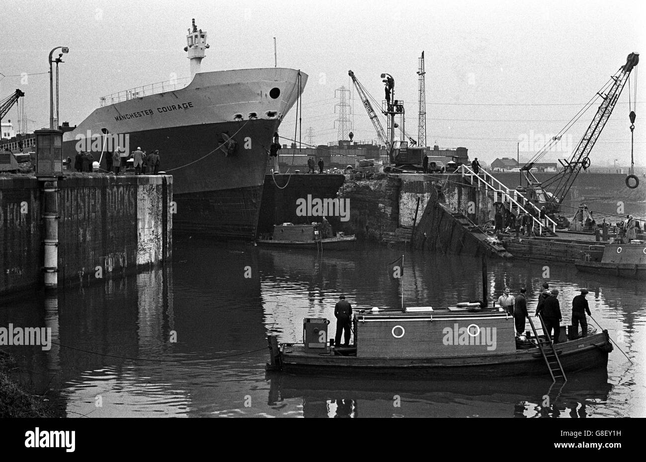 The 12,000-ton Manchester Courage, with one of the badly-damaged gates at the right. The ship, which is computerised, rammed the gates when on her way down the canal to Montreal on only her second trip since she was launched last September. The accident trapped 17 other vessels in Manchester docks. Stock Photo