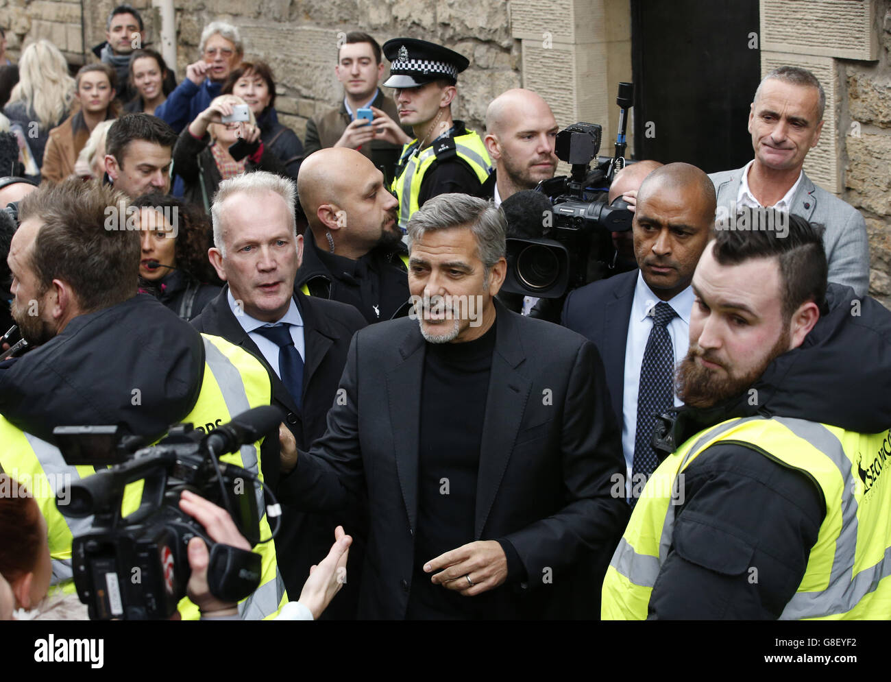 George Clooney is surrounded by media and fans as he arrives at a Social Bite cafe in Edinburgh after accepting an invitation to meet workers at the sandwich shop which helps the homeless. Stock Photo