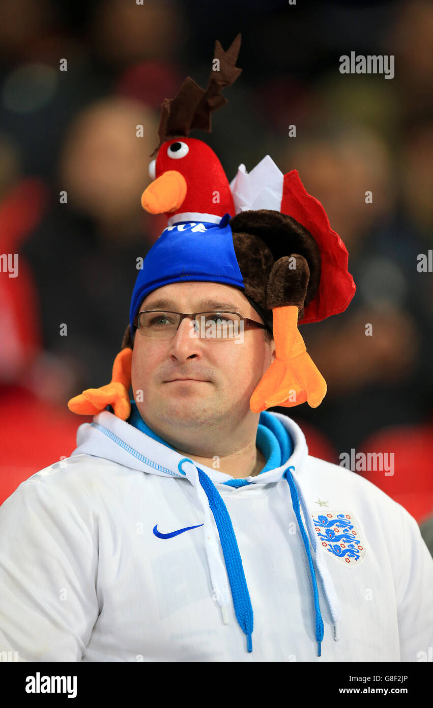 An England fan wearing a Gallic rooster hat prior to the international friendly match at Wembley Stadium, London. Stock Photo
