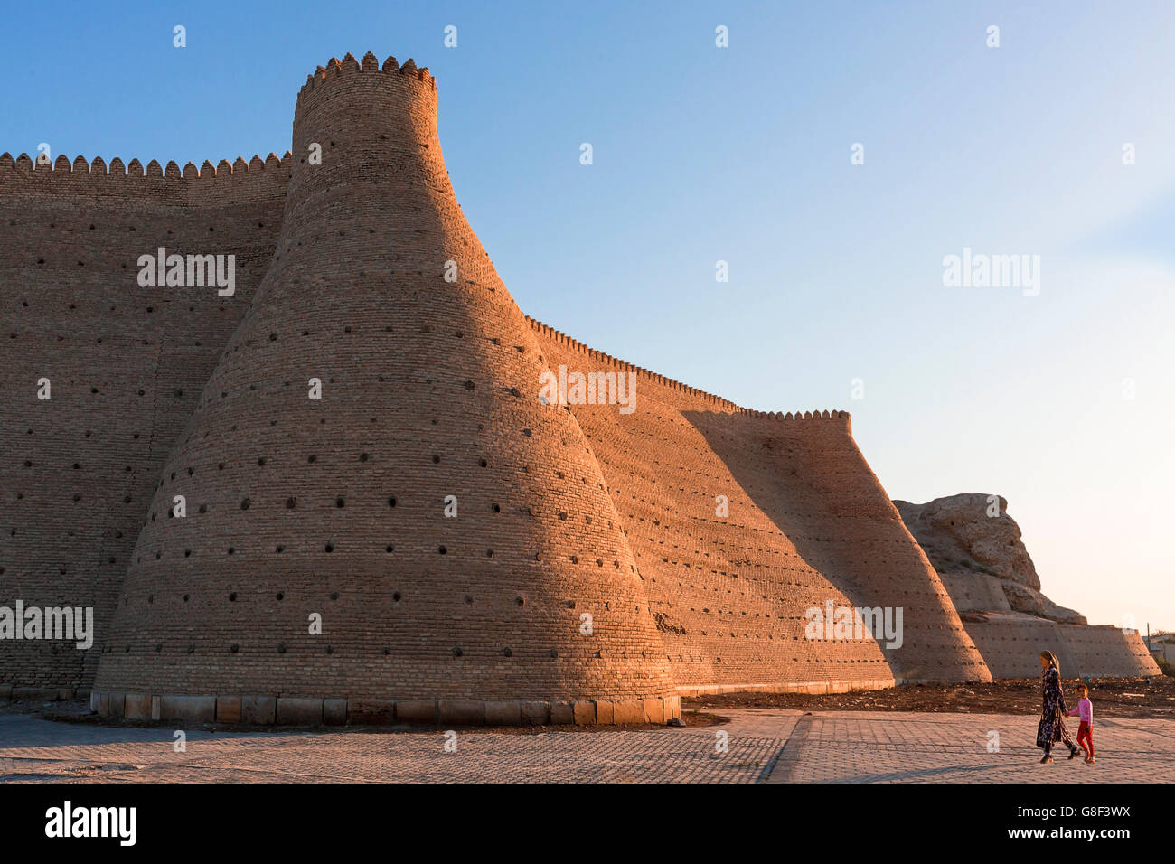 Mother and daughter walking by the city walls of Bukhara in Uzbekistan. Stock Photo