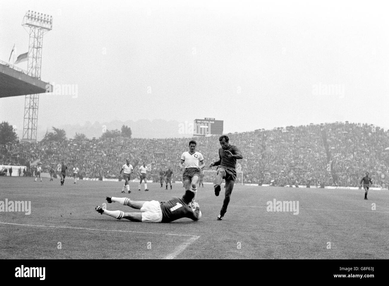 Switzerland goalkeeper Karl Elsener (l) dives to save at the feet of Spain's Joaquin Peiro (r) as teammate Werner Leimgruber (c) looks on Stock Photo