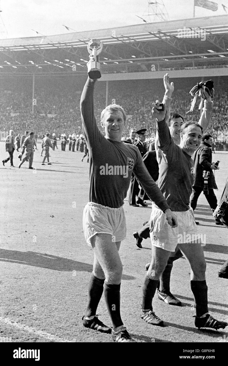 England captain Bobby Moore (l) proudly shows off the Jules Rimet trophy as he and teammates Gordon Banks (c) and George Cohen (r) parade the trophy around Wembley Stock Photo
