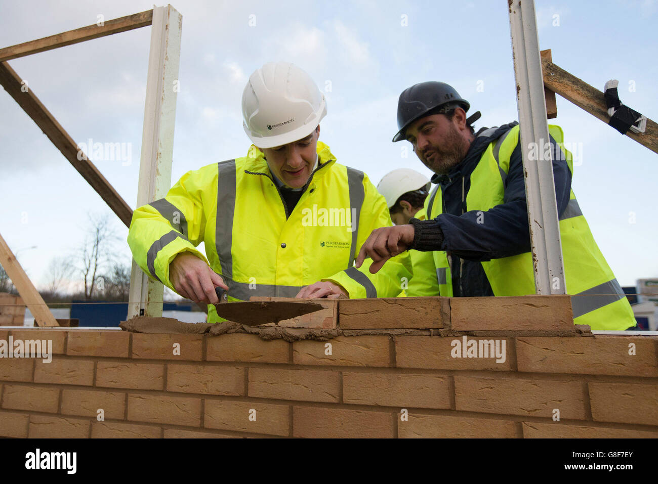 Chancellor of the Exchequer Osborne (left) lays bricks during a