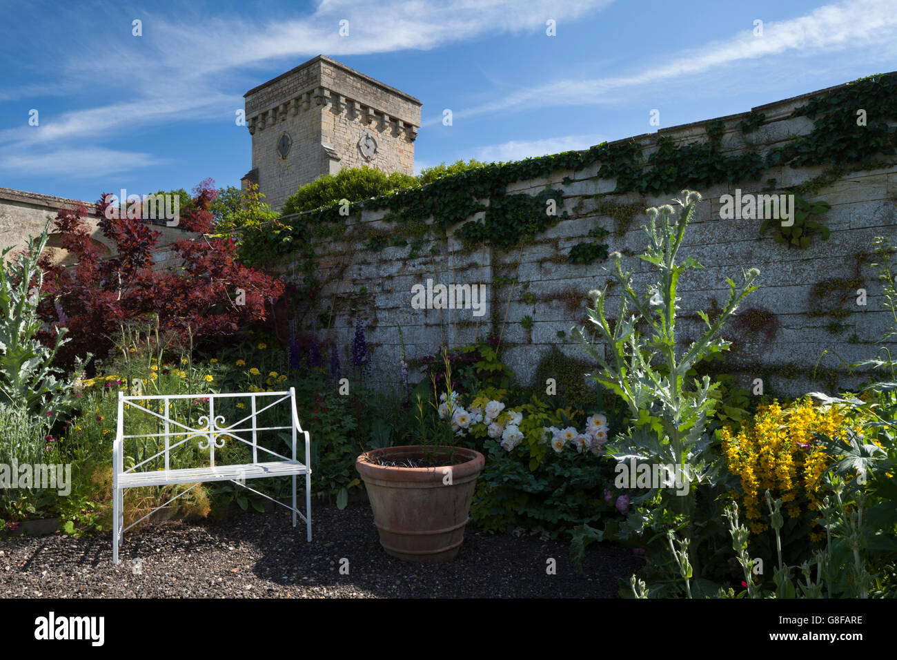 A corner of the Velvet Border with a stylish bench and within Easton Walled Garden, Lincolnshire, England Stock Photo