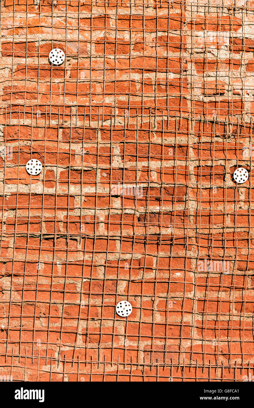 Texture of damaged brick wall with reinforcement steel grid Stock Photo