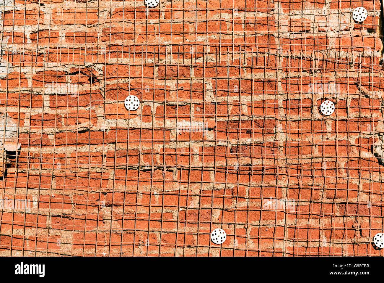 Texture of damaged brick wall with reinforcement steel mesh Stock Photo