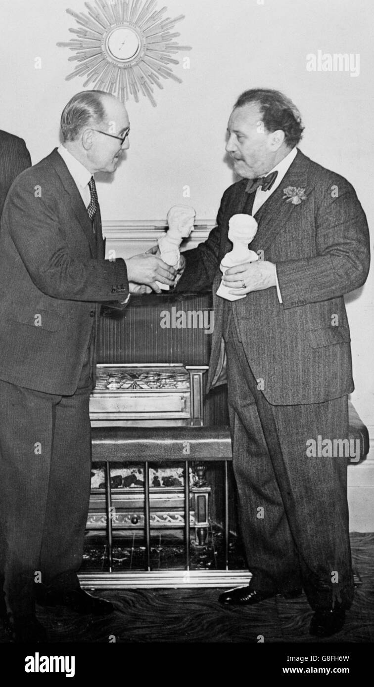 Sir Henry Wood (r) receives statuettes of the King George VI and Queen Elizabeth from W.J.P. Rodd (l), after opening the Thermoinic Club in Portland Place, London, the official BBC club. Stock Photo