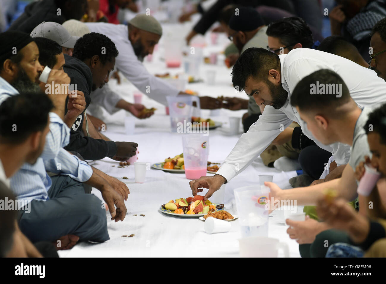 Muslim men break their fast after sunset during the holy month of Ramadan at Birmingham Central Mosque Stock Photo