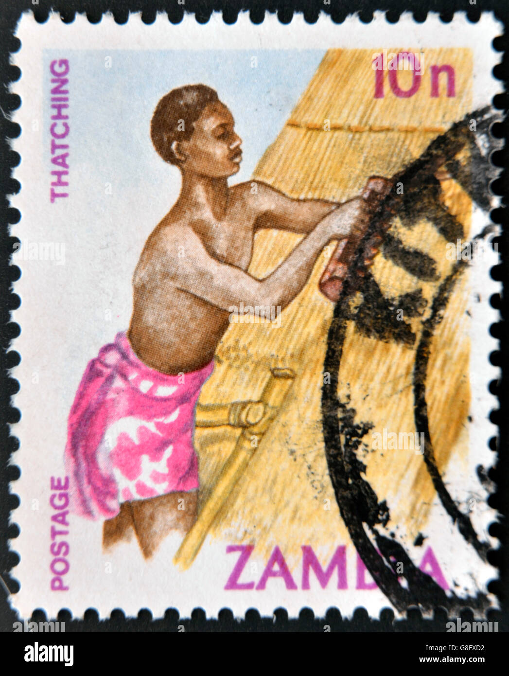 ZAMBIA - CIRCA 1981. A stamp printed in Zambia shows a man thatching home, circa 1981 Stock Photo