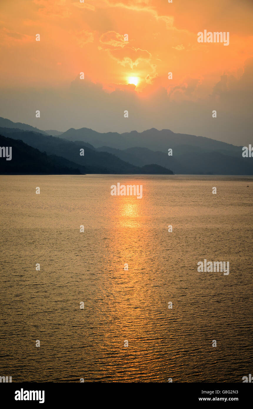 Beautiful landscape during sunset over a mountain ranges at lake in Srinakarin Dam, Kanchanaburi Province, Thailand Stock Photo