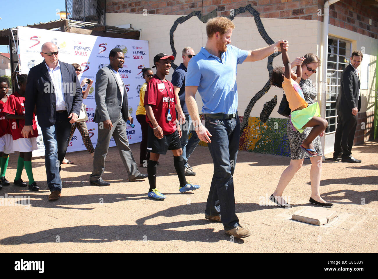 Prince Harry and Sian Price from the British High Commission play with Sinentlantla Jacobs, four, during a visit to meet children from local communities at the Football for Hope Centre in the Khayelitsha Township on the first day of his visit to South Africa. Stock Photo