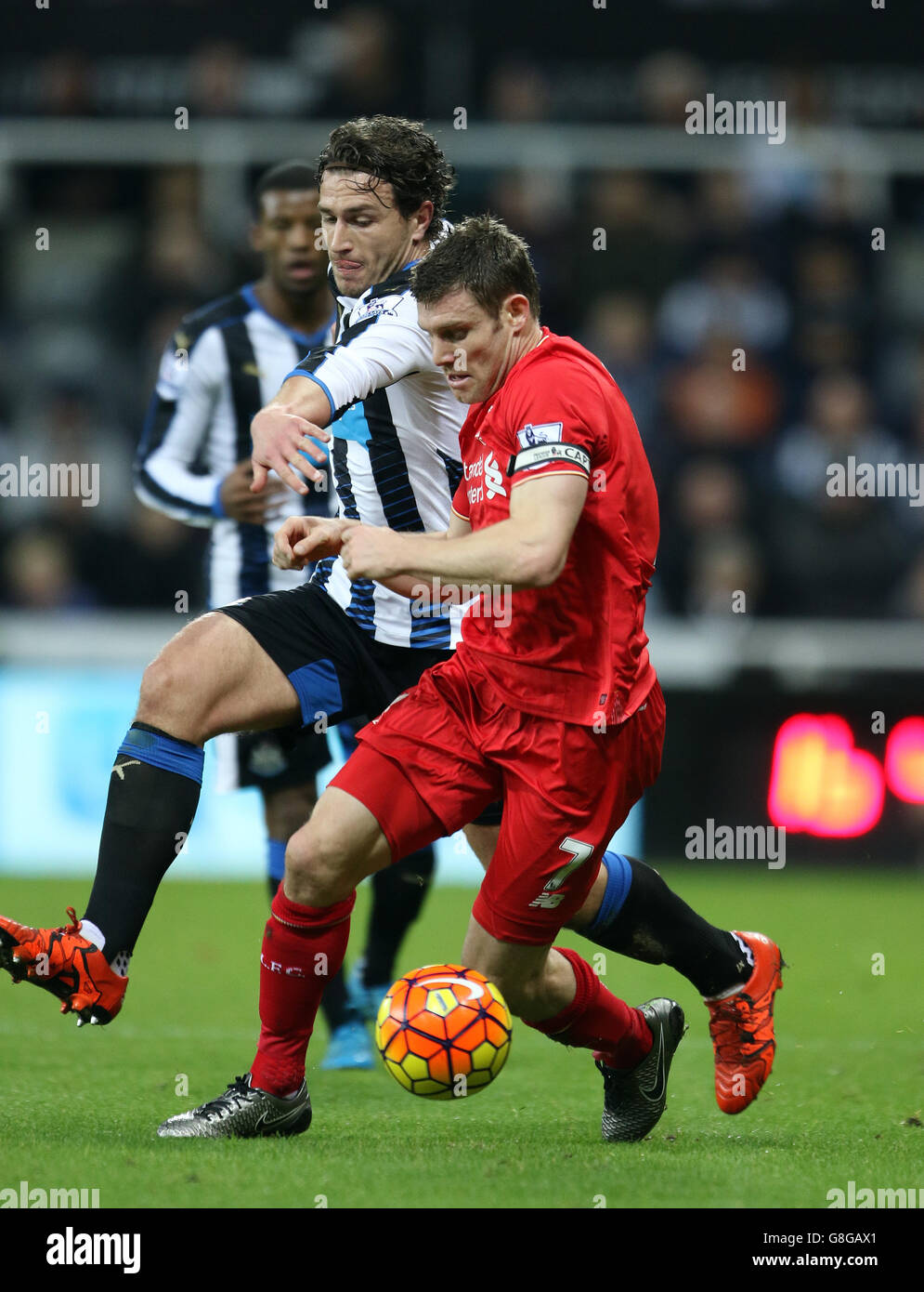 Newcastle United's Daryl Janmaat (left) tackles Liverpool's James Milner during the Barclays Premier League match at St James' Park, Newcastle. Stock Photo