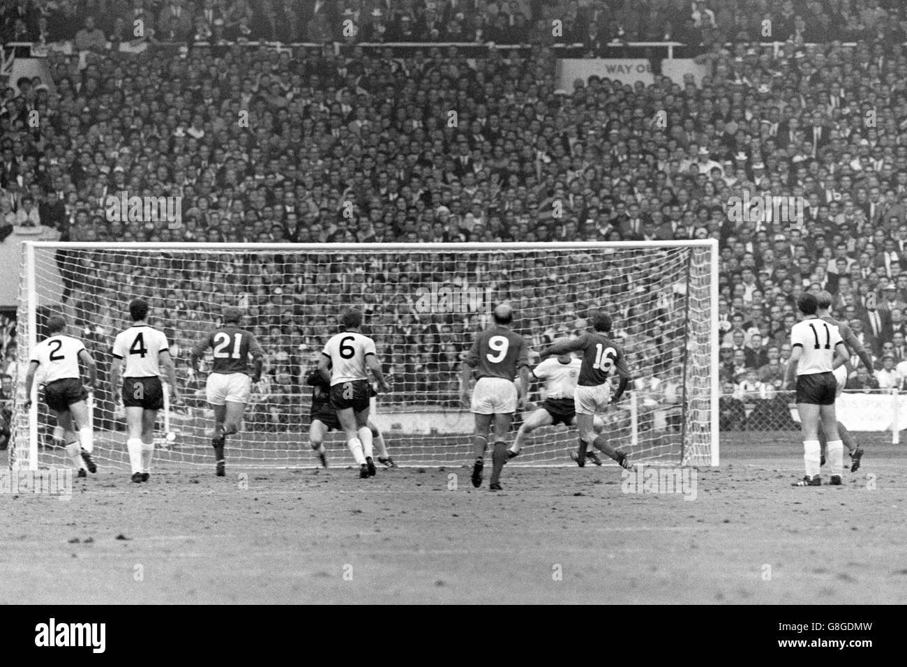 England's Martin Peters (third r) lashes his team's second goal past West Germany goalkeeper Hans Tilkowski (fourth l, hidden), watched by teammates Jack Charlton (r), Bobby Charlton (fifth r) and Roger Hunt (third l), and West Germany's Horst-Dieter Hottges (l), Franz Beckenbauer (second l), Wolfgang Weber (fourth l), Lothar Emmerich (second r) and Karl-Heinz Schnellinger (fourth r) Stock Photo