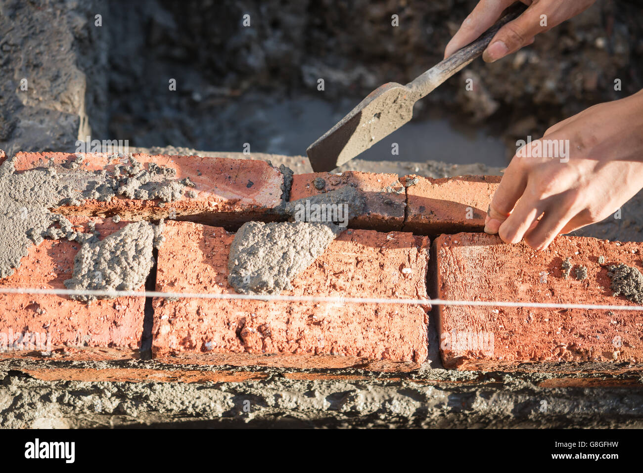 plasterer making up a brick wall with cement Stock Photo