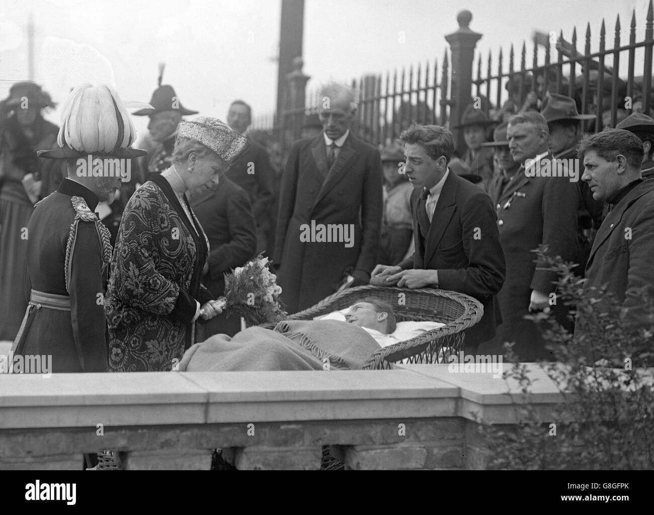 Queen Mary is presented with a bouquet of flowers as she meets Mr Knibs, a patient at St George's Hospital in Shadwell. Stock Photo