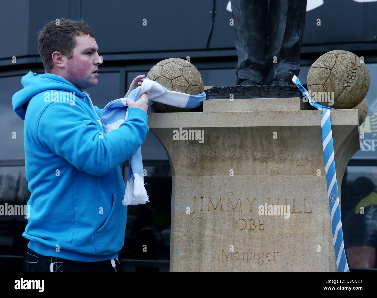Jimmy Hill death. A Coventry City fan hangs a scarf on the Jimmy Hill statue near the Ricoh Arena, Coventry. Stock Photo