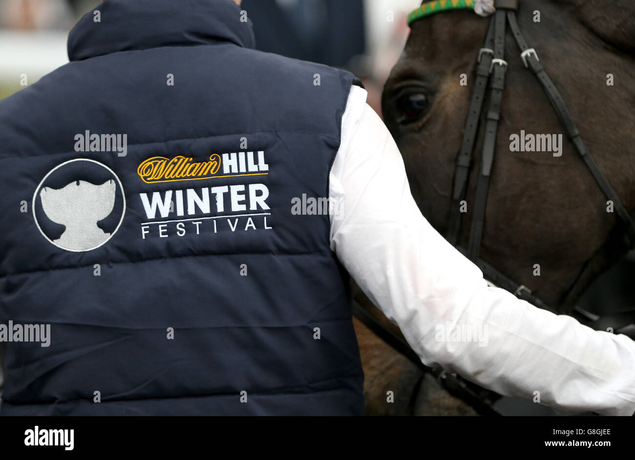 Kempton Park Races - William Hill Winter Festival - Day One. A stable hand wears a William Hill Winter festival branded gillet Stock Photo